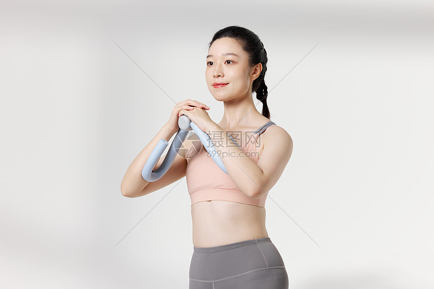 运动女性使用瘦身器材展示动作图片