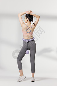使用瘦身器材展示动作的健身女性图片