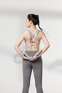 运动女性使用瘦身器材背部展示动作图片