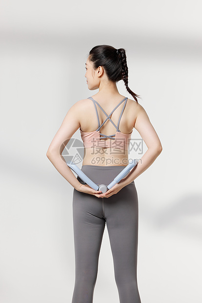 运动女性使用瘦身器材背部展示动作图片