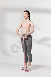 运动女性使用拉伸器材展示动作图片