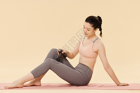运动女性使用筋膜枪放松肌肉背景图片