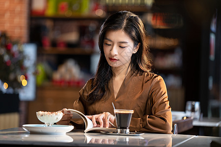 咖啡馆内在看书的青年女人图片