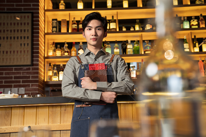 抱着菜单的餐吧男服务员图片