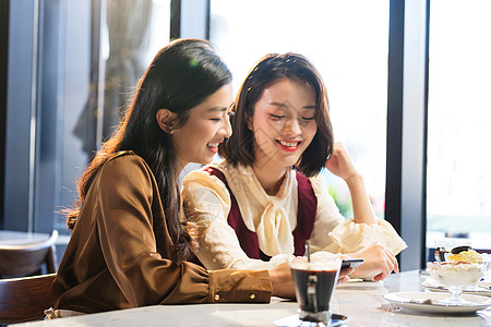 聚会分享年轻闺蜜在咖啡馆使用手机背景
