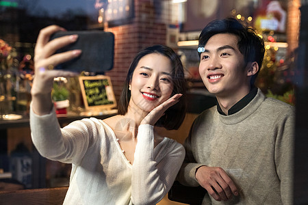 餐厅内的青年伴侣使用手机自拍图片