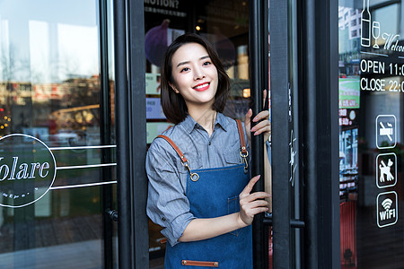 咖啡厅店面站在咖啡店门口的女服务员背景