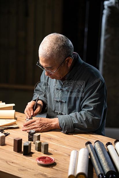 在工作室里认真雕刻印章的专家图片