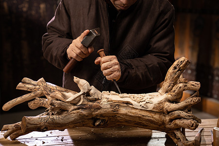 木雕师认真雕刻的工匠师与工艺品背景