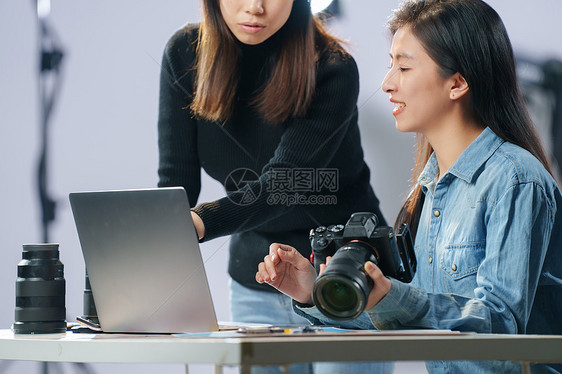 在工作室里讨论工作的青年女摄影师图片