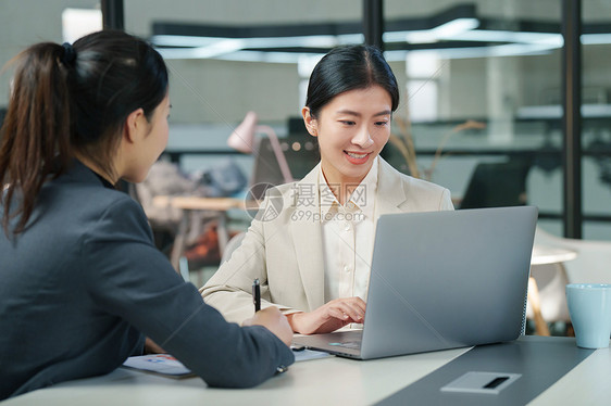 青年女设计师和顾客交谈图片