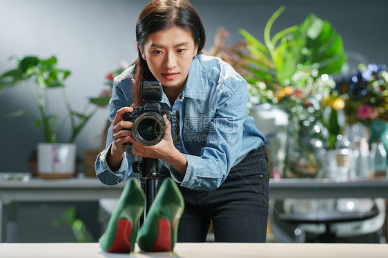 在工作室里拍照的青年女摄影师图片