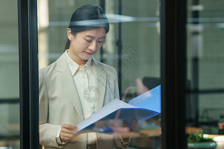 自信的青年商务女士在办公室背景图片