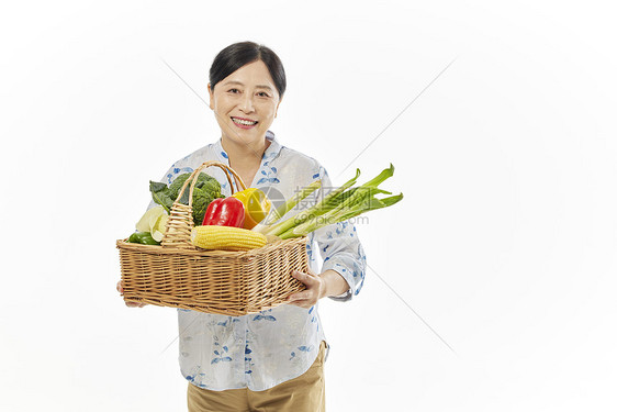 中年女性手提着一筐菜图片
