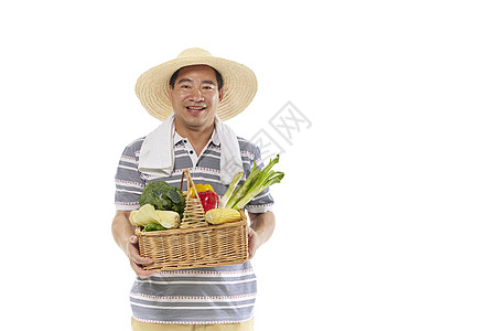 中年男性手拿一筐蔬菜图片