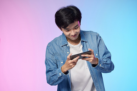 玩手机游戏使用手机玩游戏的年轻人背景