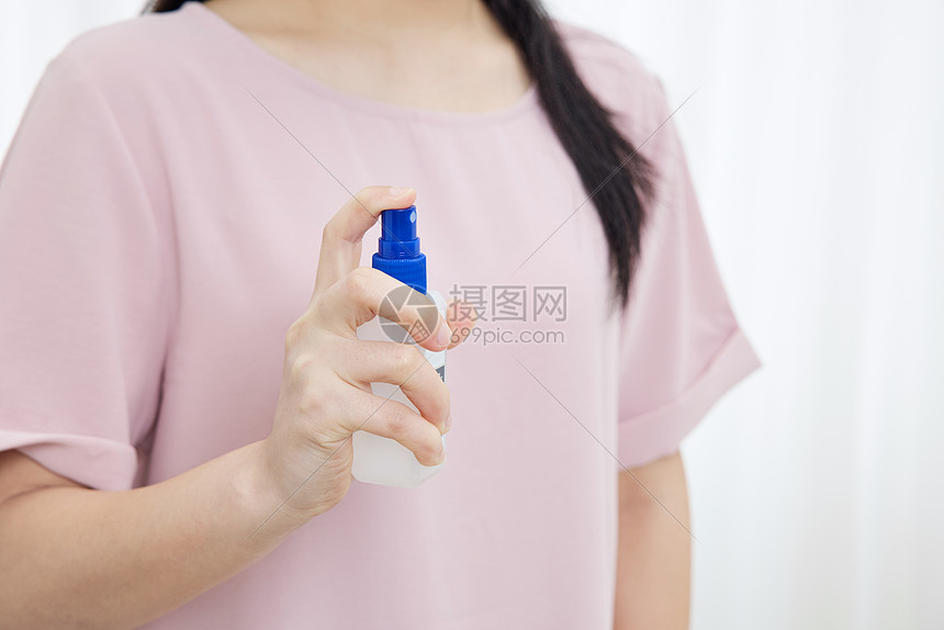 居家女性使用酒精喷雾消毒特写图片