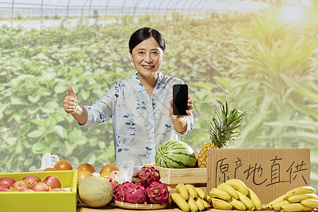 中年女性水果摊拿着手机展示点赞图片