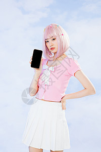 拿着手机展示的粉色头发元气女孩图片