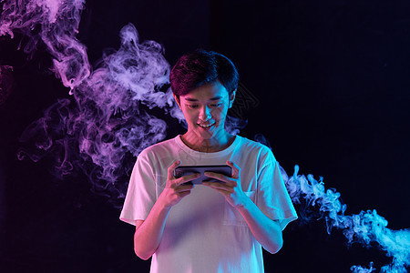 烟雾背景玩手机的男性图片