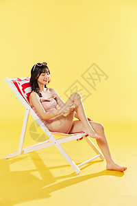 泳装美女沙滩椅涂抹防晒霜图片
