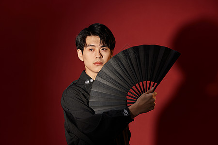 手拿折扇的新中式男青年背景图片