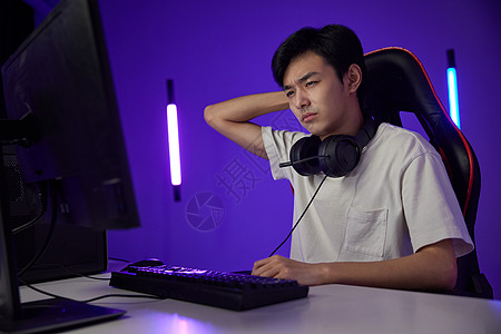 脾气暴躁的年轻男性玩电脑游戏图片