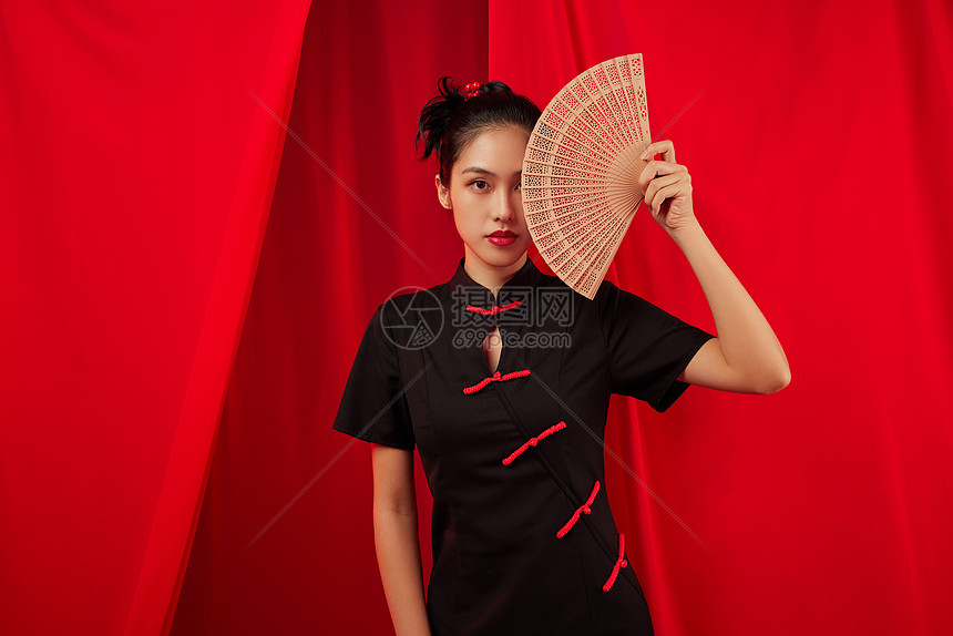 穿着旗袍的中国风美女手拿折扇图片
