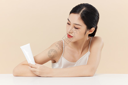 手拿饰品手拿化妆品的美丽青年女性背景