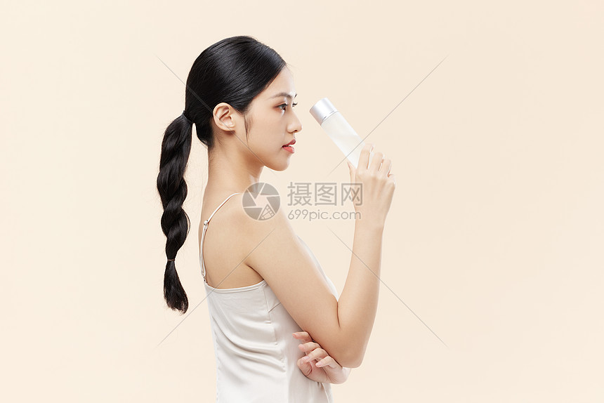 年轻女性手拿护肤水图片