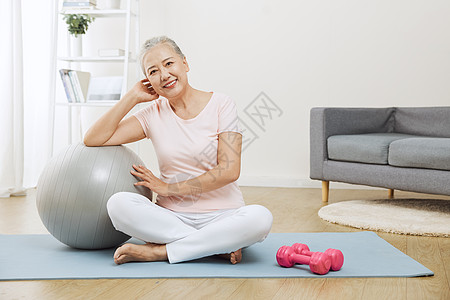 坐在瑜伽垫上的老年女性图片