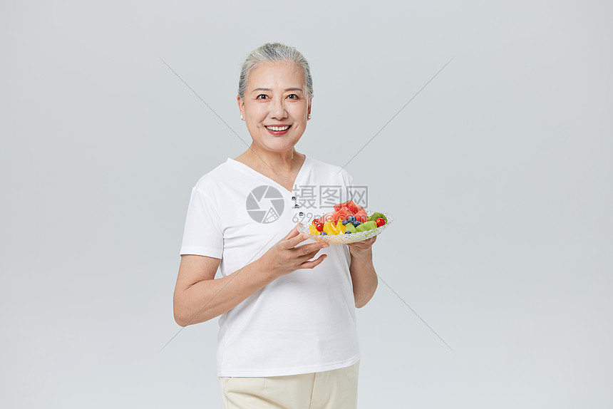吃水果沙拉的健康老年人图片