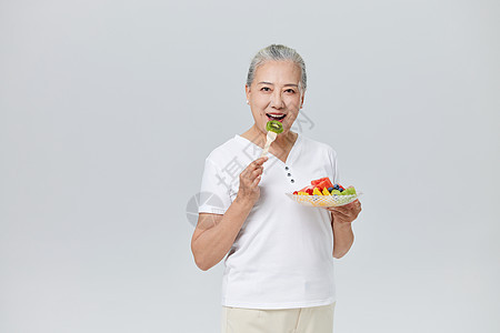 吃水果沙拉的健康老年人图片