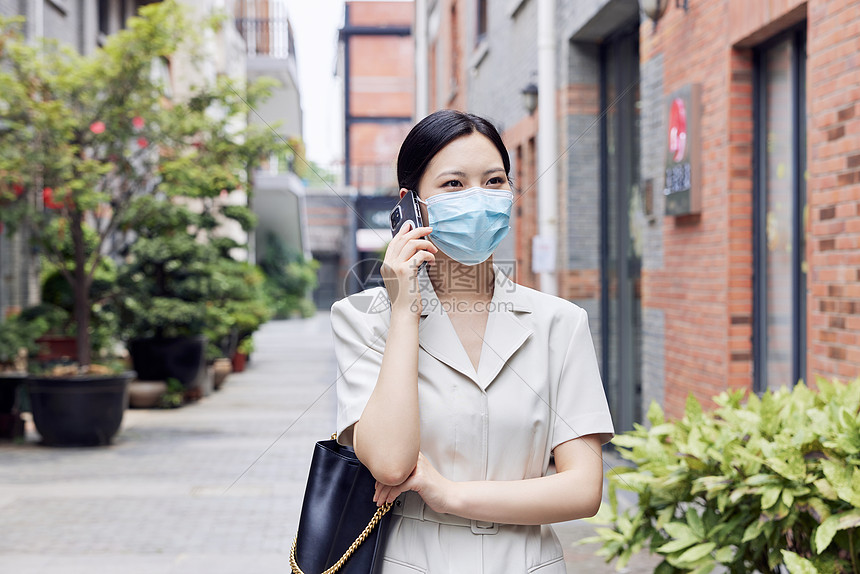 戴口罩的商务女青年室外打电话图片