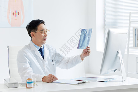 医疗专家坐在电脑前观察X光片图片