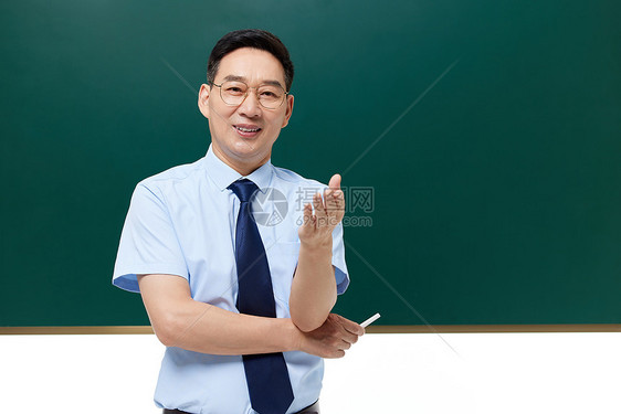 中年男教授手拿粉笔站在黑板前图片