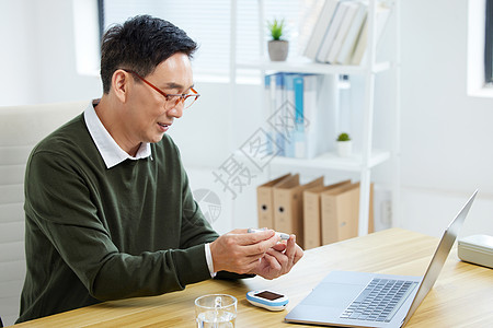 中年男性检测血糖背景图片