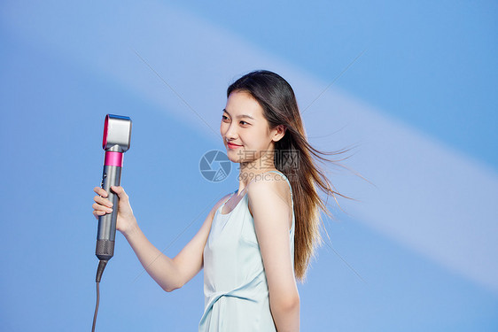 用吹风机吹头发的美女图片