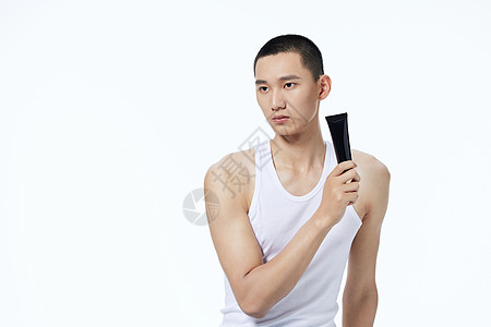 手拿护肤品的男性背景图片