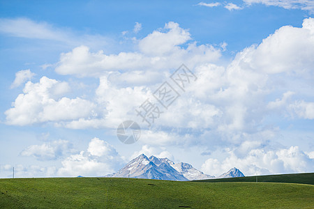 蓝天白云草原深处的雪山图片