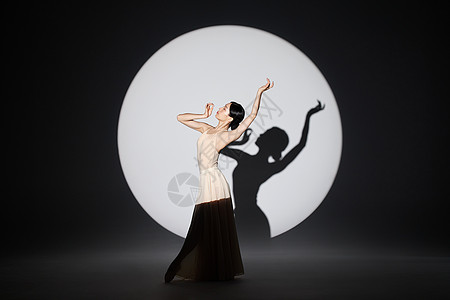 聚光灯下的女性舞者起舞形象背景图片