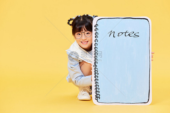 躲在笔记本后面的小女孩图片