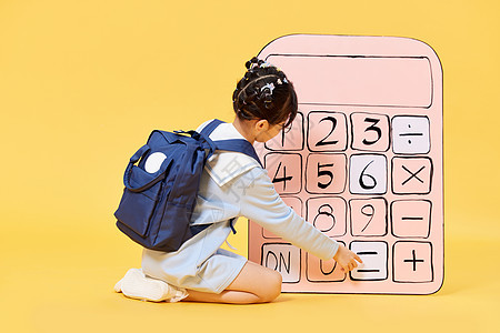 背着书包使用大号计算器的小女孩图片