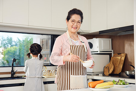 老奶奶和孙女在厨房备菜图片