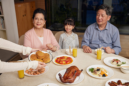 中秋家庭聚餐妈妈手端月饼图片