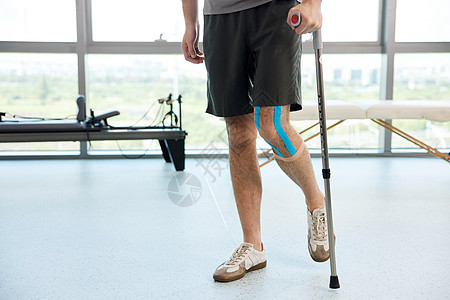 拄着拐杖的腿伤患者背景图片