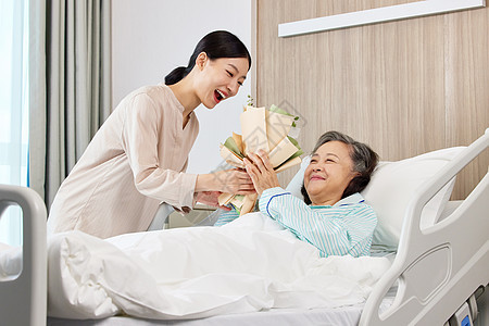 手拿花束的青年女性探望生病住院的老人图片