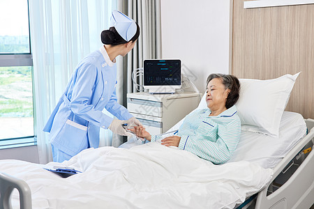 护士与心电图护士为老年患者佩戴心电图血氧监测指夹背景