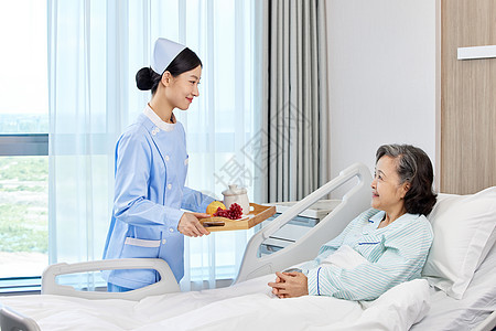 女护士细心照顾住院老年病患背景图片