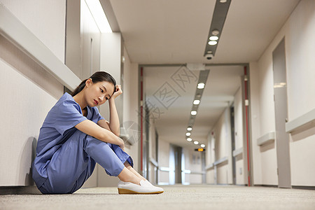 医院建筑医院走廊上的女护工劳累疲惫形象背景